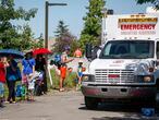 A Salvation Army EMS vehicle is setup as a cooling station as people lineup to get into a splash park while trying to beat the heat in Calgary, Alta., Tuesday, June 29, 2021. Environment Canada warns the torrid heat wave that has settled over much of Western Canada won't lift for days. THE CANADIAN PRESS/Jeff McIntosh