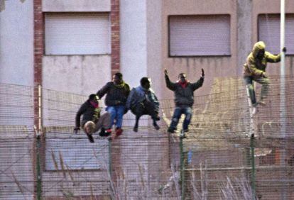 Inmigrantes saltan la valla de Melilla el pasado febrero.
