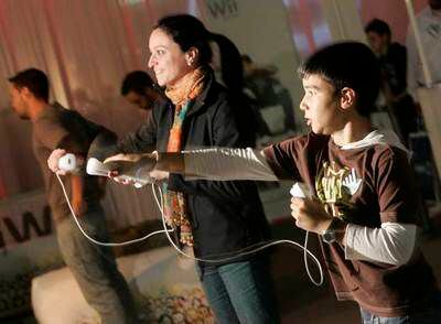 Una mujer y un nilño juegan con una Wii de Nintendo.