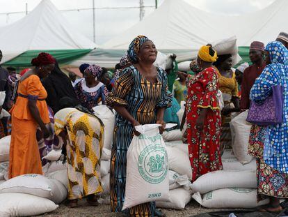 Varias mujeres recogen sacos de alimentos en una distribución en Abuja, organizada por el Gobierno de Nigeria para amortiguar el alto coste de vida.