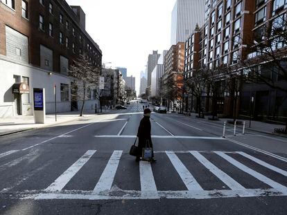 Una mujer cruza una calle en Nueva York.