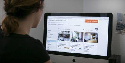 Una joven consulta los precios de los pisos de alquiler en una página web de anuncios.