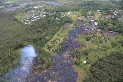 Los habitantes de la zona están bajo una advertencia de evacuación aunque muchos ya han abandonado el área voluntariamente. En la imagen, vista aérea de la zona afectada por la lengua de lava cerca de Pahoa, 30 de octubre de 2014.