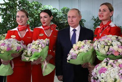 Vladímir Putin, con unas azafatas aéreas en un acto público en Moscú el pasado 4 de marzo.