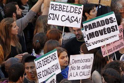 Los manifestantes reunidos en la Puerta del Sol, en Madrid, llevan pancartas contra la banca, el paro o la falta de vivienda.