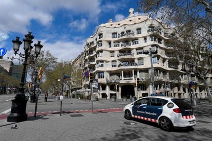 Un coche de los Mossos delante de la Pedrera de Gaudí, en Barcelona, vacía durante el confinamiento.