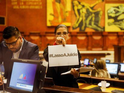 Una mujer sostiene un papel en el que se lee Lasso a juicio, en la Asamblea Nacional de Ecuador, este sábado.