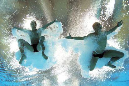 Los cubanos José Antonio Guerra y Jeinkler Aguirre caen al agua durante la competición de salto masculino desde una plataforma de 10 metros.