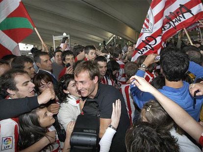 El jugador del Athletic Yeste, en el centro, entre una nube de seguidores rojiblancos en el aeropuerto a Loiu.