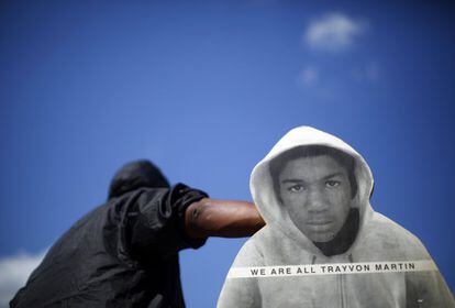 Un hombre sostiene una pancarta con la figura de Trayvon Martin y con el lema: 'Todos somos Trayvon Martin'.