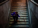 Un empleado del metro limpia la nieve en las eslaleras de una de las estaciones durante el temporal de nieve en Madrid.