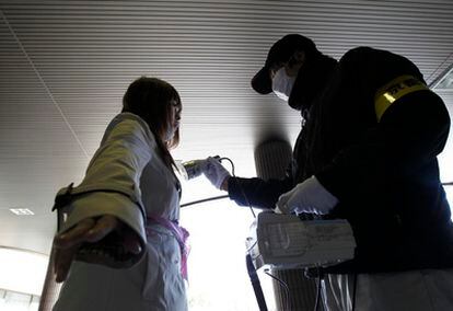 Una joven mide su control de radiactividad en la prefectura de Fukushima.