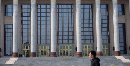 Un hombre pasa frente al Gran Salón del Pueblo en Pekín. 
 