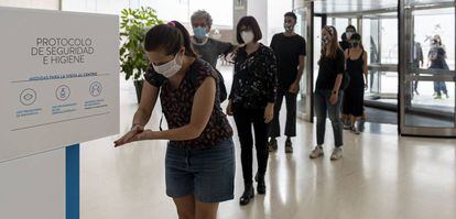 Els primers visitants es desinfecten las mans a l'entrada al CaixaForum aquest dilluns.