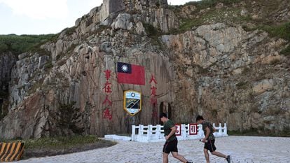 Soldiers march past a sign of the Taiwan flag on Dongyin island of Matsu archipelago in Taiwan August 15, 2022. REUTERS/Ann Wang