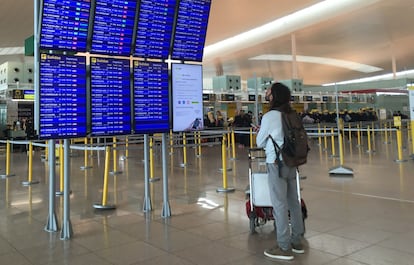 Un pasajero mira los paneles informativos hoy en la T-1 del aeropuerto de El Prat.