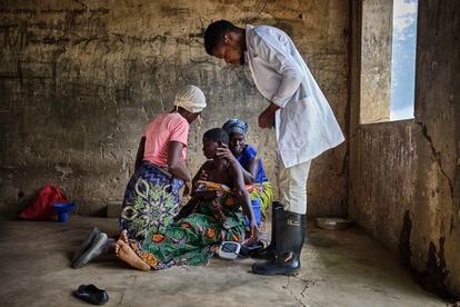 Emmanuel Chipokodzi, asistente médico del centro de salud de Mtosi, toma la tensión a una paciente enferma de cólera. Ayudada por su familia, esta mujer embarazada llegó hace 24 horas al centro de salud. Debido a su estado, Chipokodzi tiene dudas de si va a sobrevivir otro día.