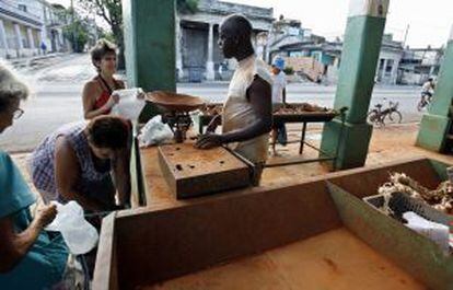 Cubanos comprar en un mercado poco abastecido en el barrio de Playa en La Habana.