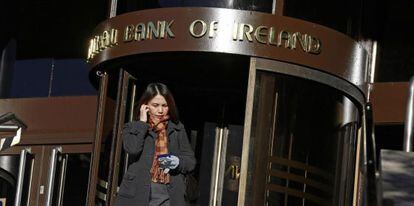 Una mujer sale del Banco de Irlanda en Dubl&iacute;n este jueves.