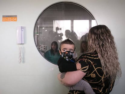 Nerea junto a su hijo Derek en el exterior de la Unidad de Trasplantes donde fue tratado; en el otro lado del cristal, Raquel, la otra madre del pequeño. En vídeo, declaraciones de las madres y de los médicos.