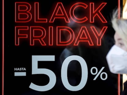 Una persona pasa ante un escaparate con promociones del Black Friday