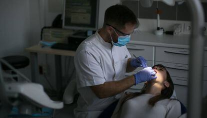 Un dentista amb una pacient a la seva consulta.