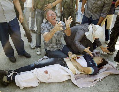 Un hombre y una mujer lloran sobre el cadáver de su hijo, muerto por los disparos de un francotirador en el barrio de Saladino, en una imagen tomada el 12 de agosto.