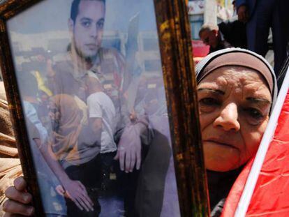 Una mujer muestra el retrato de un palestino preso en una c&aacute;rcel israel&iacute;, durante una protesta celebrada en Ramala este lunes.