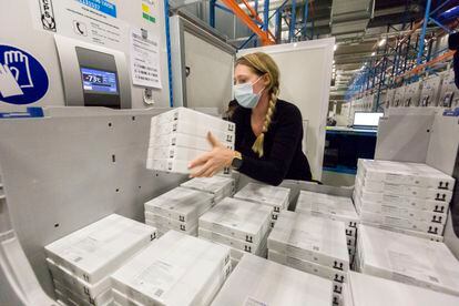 Una empleada guarda en el congelador paquetes con viales de la vacuna de Pfizer/BioNTech en la planta de de Pfizer en Puurs (Bélgica).