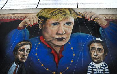 Un grafiti en una calle de Lisboa que muestra a la canciller alemana Angela Merkel controlando como títeres al primer ministro y ministro de exteriores de Portugal.