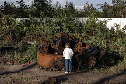 A boy looks at the remains of a destroyed Russian tank near the Ukrainian town of Irpin in kyiv province on Wednesday.