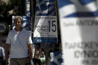 Un hombre camina junto a varios carteles del partido conservador griego Nueva Democracia (ND), hoy en Atenas.