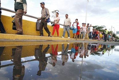 Venezolanos cruzan el puente Simón Bolívar después de hacer compras en Colombia.