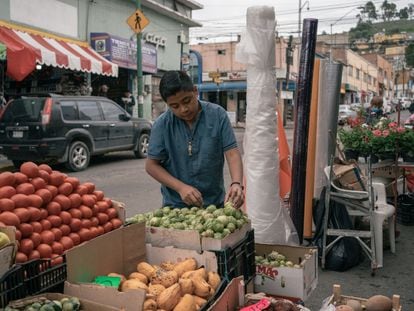 Un vendedor acomoda tomates verdes en un puesto callejero de verduras en la ciudad de Toluca, en el Estado de México.