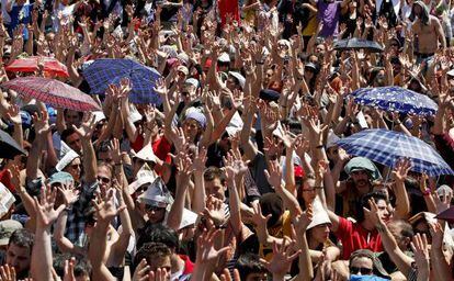 Los acampados de Sol levantan sus manos para votar en la asamblea.