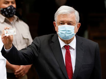 El presidente Andrés Manuel López Obrador muestra su credencial de elector al votar este domingo.