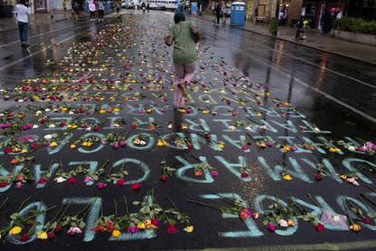 Flores y los nombres de las víctimas de la violencia policial, en la calle de Minneapolis en la que murió George Floyd a manos de la policía el pasado junio.