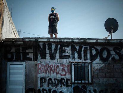 Un hombre con mascarilla mira desde el techo de su casa del barrio 31 de la ciudad de Buenos Aires (Argentina), uno de los lugares con más casos de covid-19 del país.
