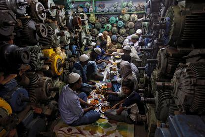 Musulmanes rompen el ayuno diario en un taller de bombas de agua, en el casco antiguo de Delhi (India).
