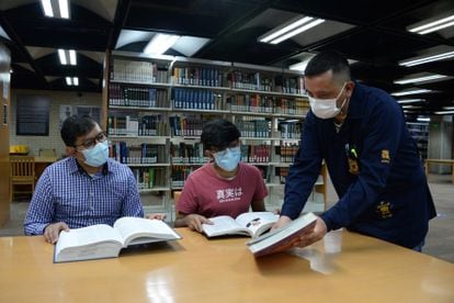 Un bibliotecario asiste a dos visitantes de la Biblioteca Nacional, en Ciudad de México, en mayo.