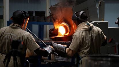 Dos empleados de la refinería ugandesa African Gold Refinery trabajan en el horno.