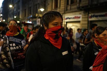 Mujeres con la cara cubierta participan en la protesta por los 9 años de la desaparición de los estudiantes.