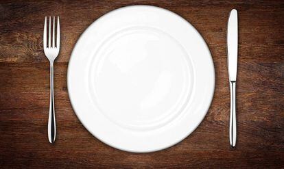 Un plato en medio de cubiertos.