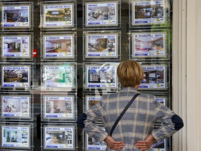 Una mujer mira la oferta de viviendas en una inmobiliaria, en una imagen de archivo.