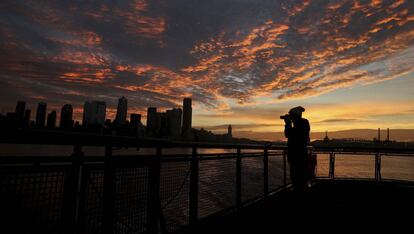 Una mujer fotograf&iacute;a el atardecer en Seattle (Estados Unidos), ejemplo de ciudad global gracias al empuje de las grandes empresas tecnol&oacute;gicas. 