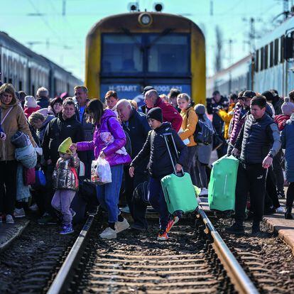 Ukrainian refugees cross the train tracks in Zahony, Hungary.