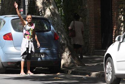 Una mujer señala un hueco para aparcar en una calle de Granada, donde el Ayuntamiento requisa el dinero a los <i>gorrillas</i>.