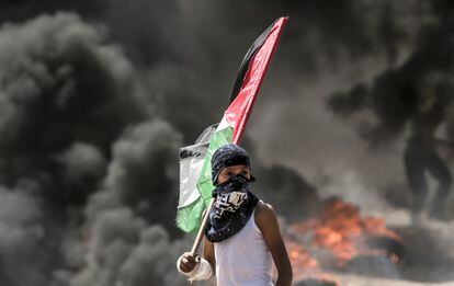 Un niño sujeta la bandera palestina durante los enfrentamientos con las tropas israelíes en la franja de Gaza. 