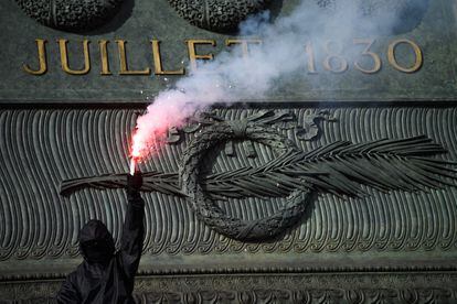 Demonstrant niesie pochodnię w piątek w Paryżu podczas protestów przeciwko reformie emerytalnej Macrona.