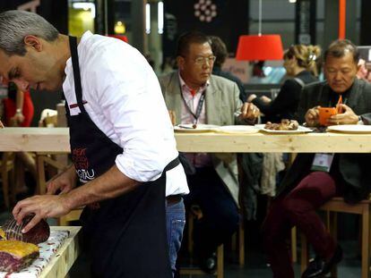 Un cocinero prepara un plato en un expositor de Alimentaria.